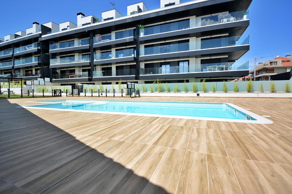 una piscina vacía frente a un edificio en Impresionante apartamento con piscina en Sanxenxo, en Sanxenxo