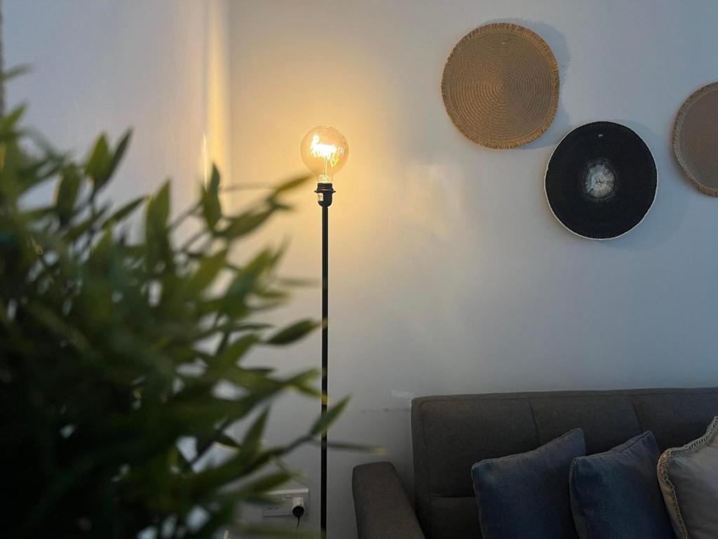 a floor lamp in a living room next to a couch at Luxury Lavender in Larnaca
