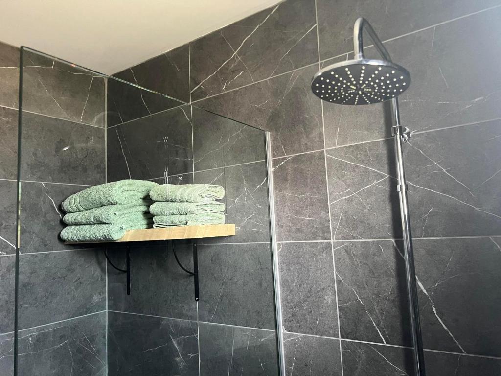 a shower with four towels on a shelf in a bathroom at Luxury Lavender in Larnaca
