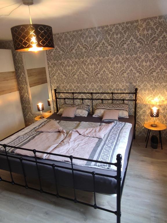 a large bed in a bedroom with two lamps at Zum Buchenblick in Sankt Wendel