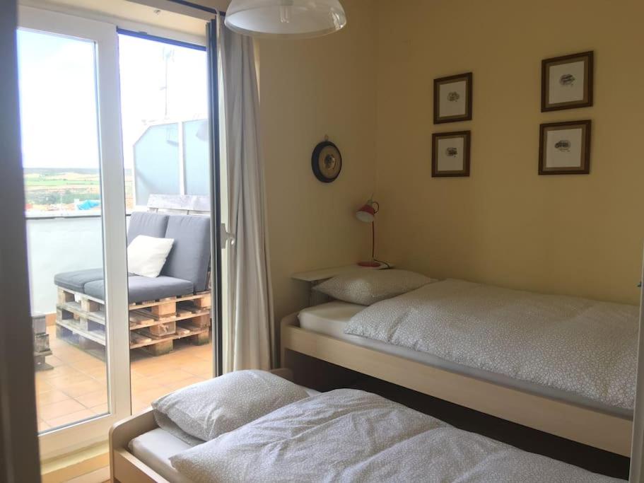 a bedroom with two beds and a sliding glass door at ÁTICO CENTRO LOGROÑO VISTAS y garaje in Logroño