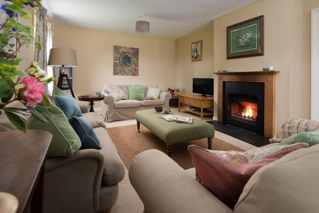 a living room with couches and a fireplace at Pirnie Cottage in Kelso