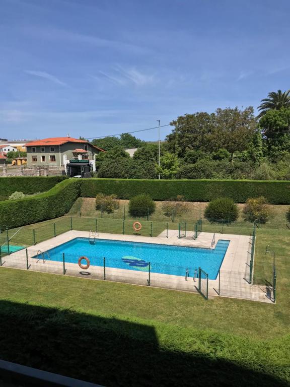 a large swimming pool in a yard next to a house at Apartamento Olmeca in Santander
