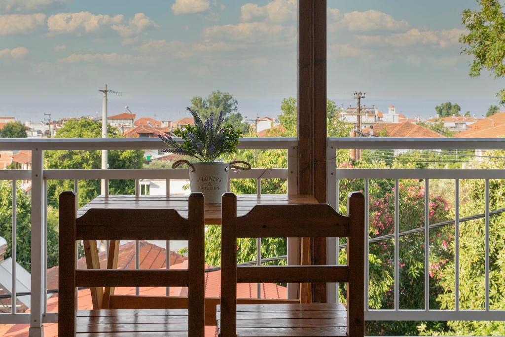 a porch with a table and a plant on a balcony at Gravanis Studios in Platamonas