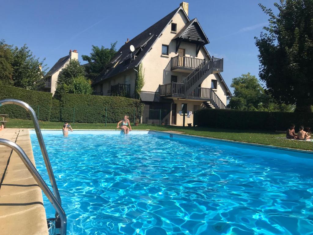 une piscine devant une maison dans l'établissement Résidence le Manoir du Mont Canisy Piscine & Tennis, à Deauville