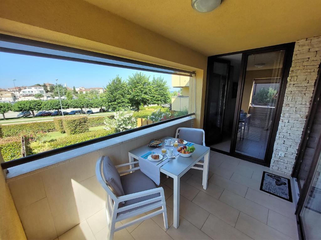 a small table and chairs in a room with a large window at Lucia Exclusive with parking in the garage in Poreč