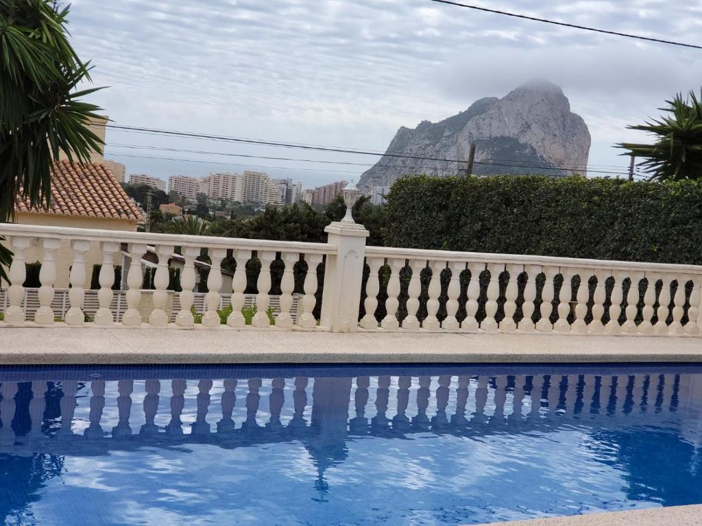 a white fence with a mountain in the background at Aпартаменты на Ortenbach in Casas de Torrat