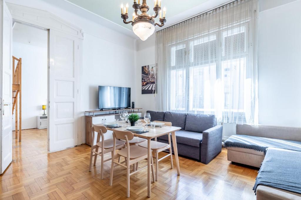 un soggiorno con tavolo e divano di Huge Apartment in the city center a Budapest