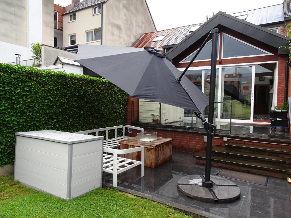 un parasol noir, une table et un banc dans l'établissement on-ge-woon(st)ad Hasselt (nabij centrum), à Hasselt