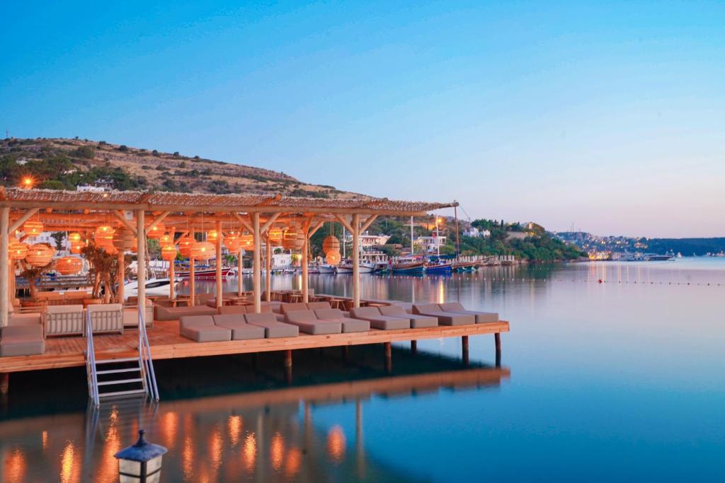 a dock with lounge chairs on the water at Faros Hotel Bodrum - Special Category in Golturkbuku