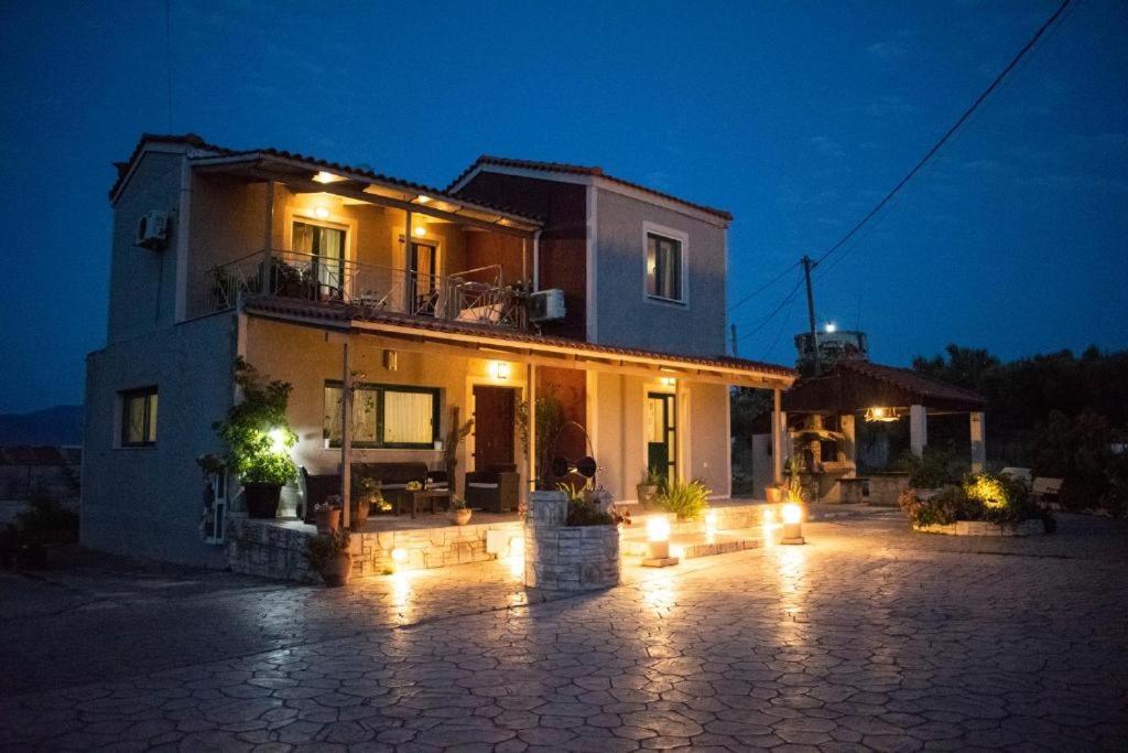 een huis met lichten er 's nachts voor bij Villeta Nikol “Νηνεμία” in Lixouri