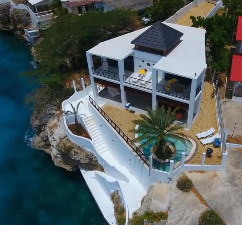 an aerial view of a house with a swimming pool at Yemaya Villa Curaçao Unique-Oceanfront-Private stairway to sea! in Willemstad