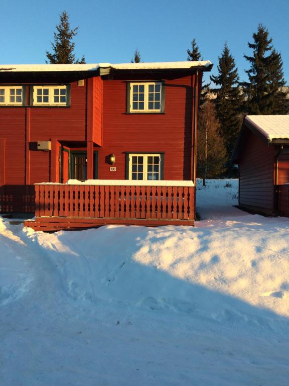 a red house with a fence in the snow at Hafjell/Lillehammer Sorlia 3 bedroom Cabin in Hafjell