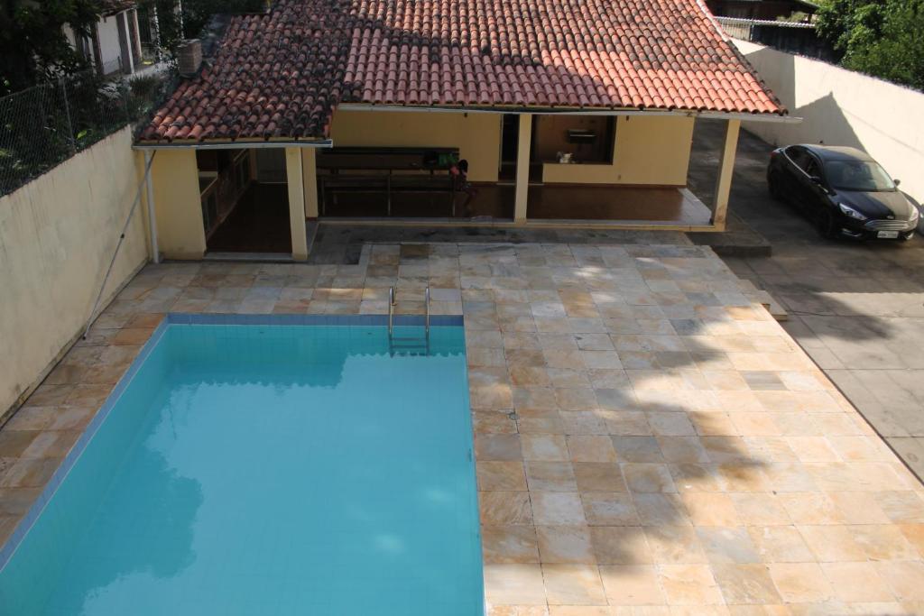 uma piscina em frente a uma casa em Casa muito espaçosa privativa com Piscina, Churrasqueira e área gourmet em Araruama