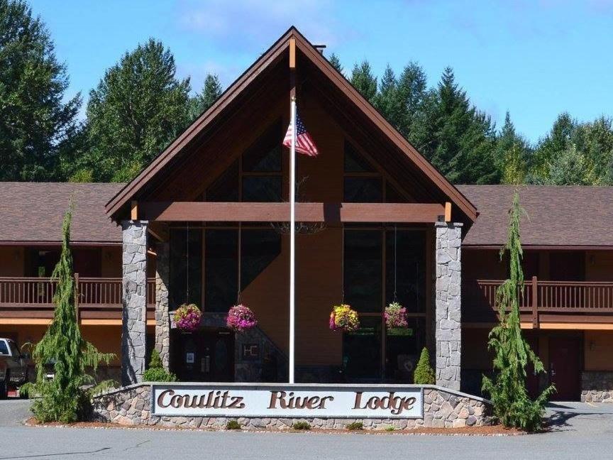 a lodge with an american flag in front of it at Cowlitz River Lodge in Packwood