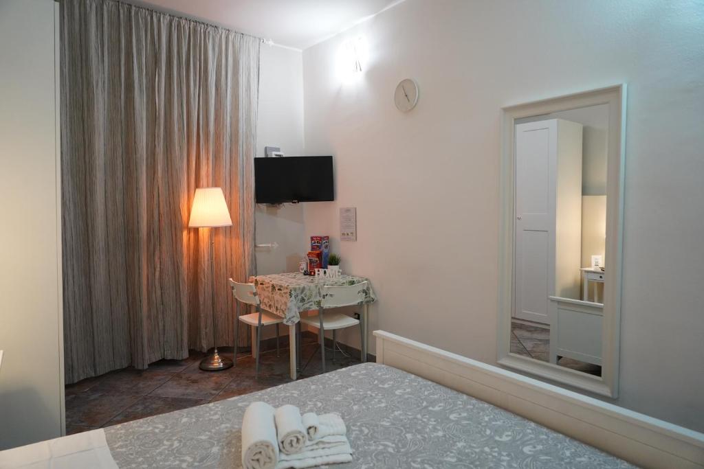 Pokój hotelowy z łóżkiem, stołem i lustrem w obiekcie Magrì Apartments Catania w Katanii