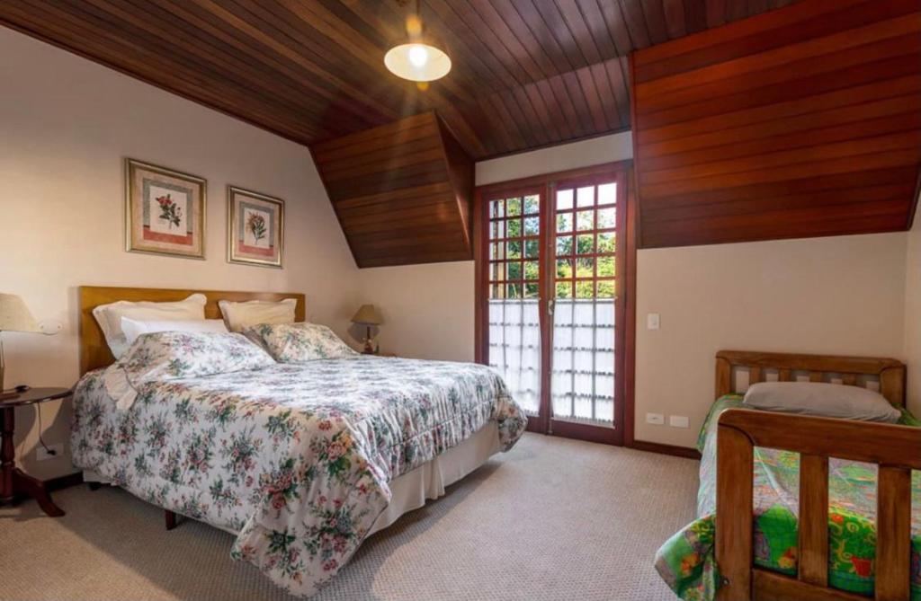 a bedroom with a bed and a wooden ceiling at Suítes Villa Panorama in Campos do Jordão