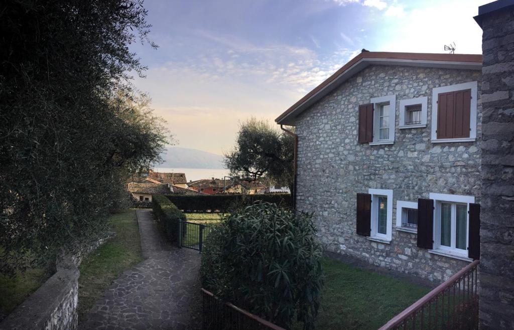 a stone house with a pathway next to a building at Casa Marisa in Gargnano