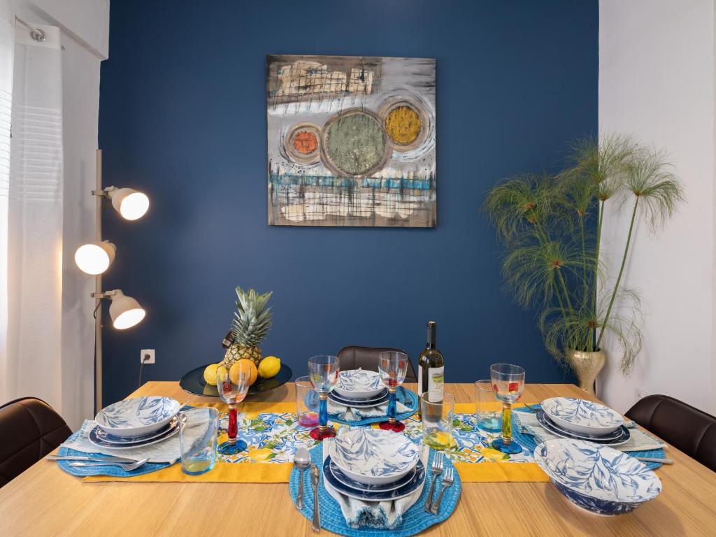 a dining room with a table with a blue wall at Blue Siri Apartment in Heraklio