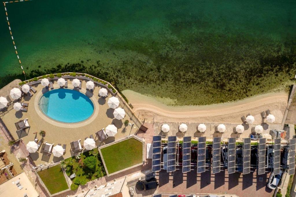 an aerial view of a resort with a pool and umbrellas at Hotel Splendido in Kotor