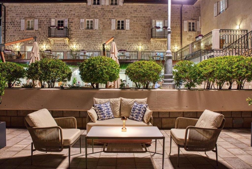 a patio with a couch and chairs and a table at Hotel Splendido in Kotor