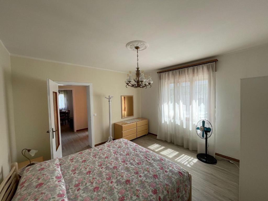 um quarto com uma cama, uma cómoda e uma janela em Margi House em Bigolino