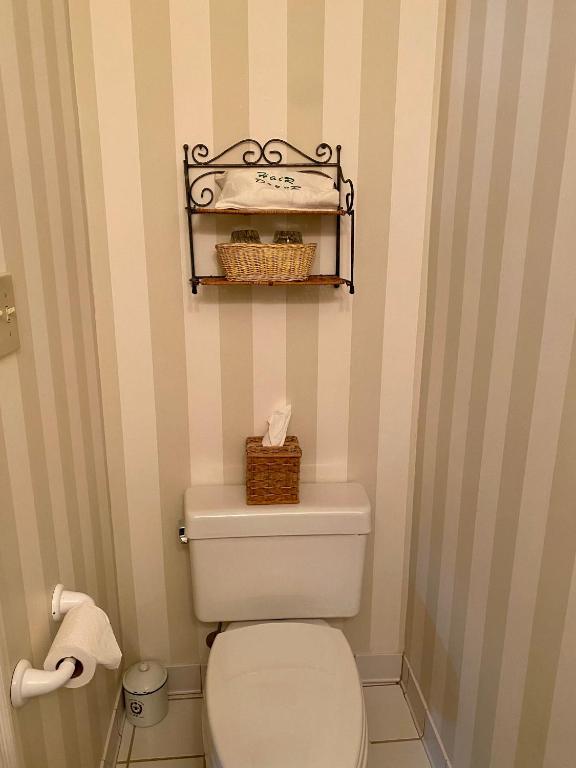 a bathroom with a toilet with a shelf above it at The Cypress Inn in Conway