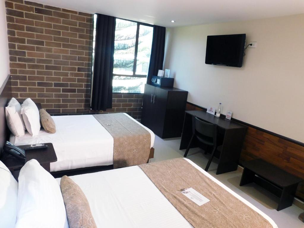 Postel nebo postele na pokoji v ubytování Hotel Acqua Medellín
