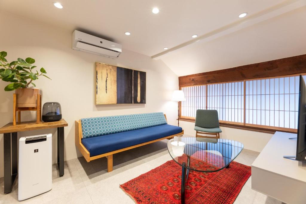 a living room with a couch and a table at MACHIYA HOTEL madoka - Vacation STAY 65847v in Izumo