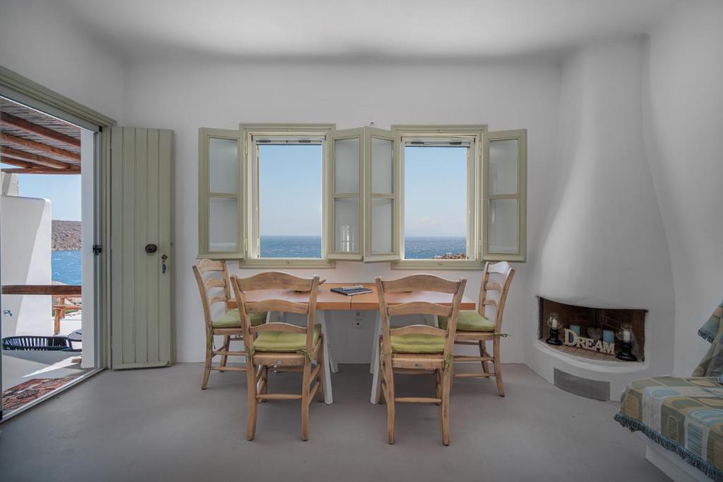 a dining room with a table and chairs and windows at Villa Ostria in Rámos