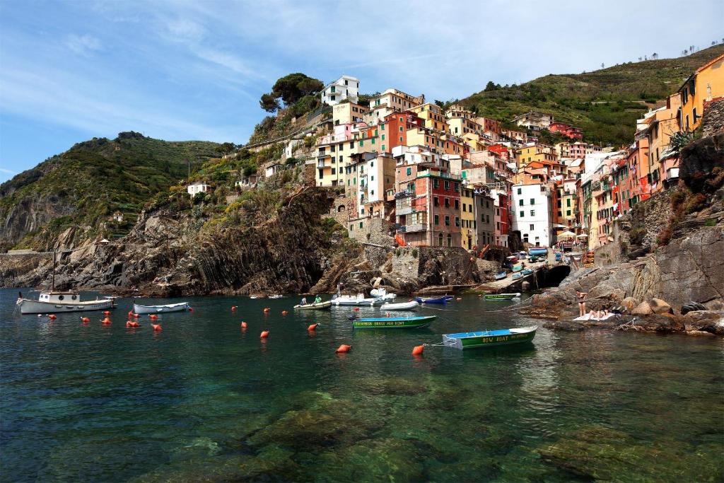 a group of boats in the water in front of a city at In Tracastello - parking - in Riomaggiore
