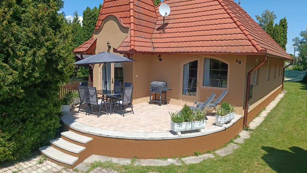 Casa pequeña con patio y sombrilla en Vica Apartman, en Balatonberény
