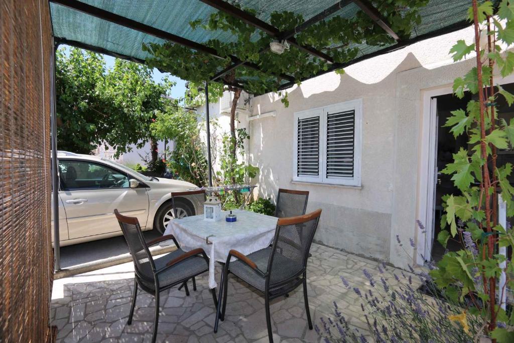 a table and chairs on a patio with a car at Apartment Silo 22 in Šilo
