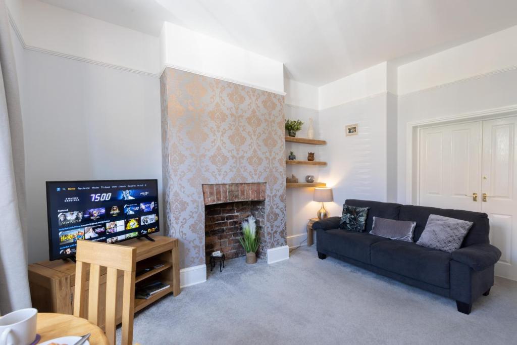 een woonkamer met een bank en een open haard bij Bootham Apartment 32 - Free Parking - Five minute walk to York Minster in York