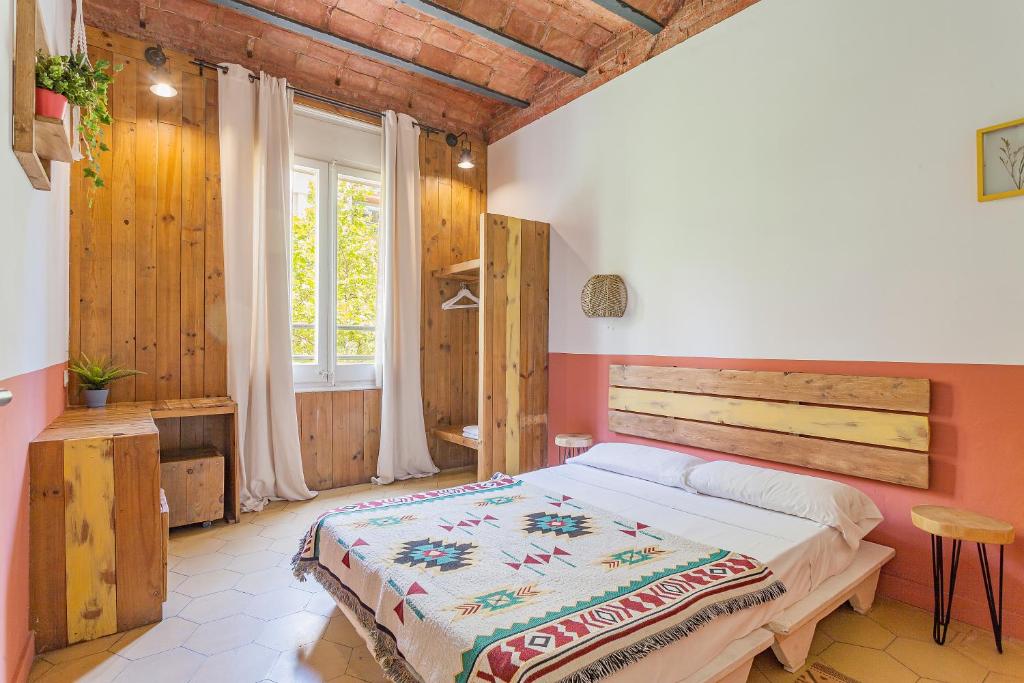 ein Schlafzimmer mit einem Bett in einem Zimmer mit Holzwänden in der Unterkunft Bird House in Barcelona