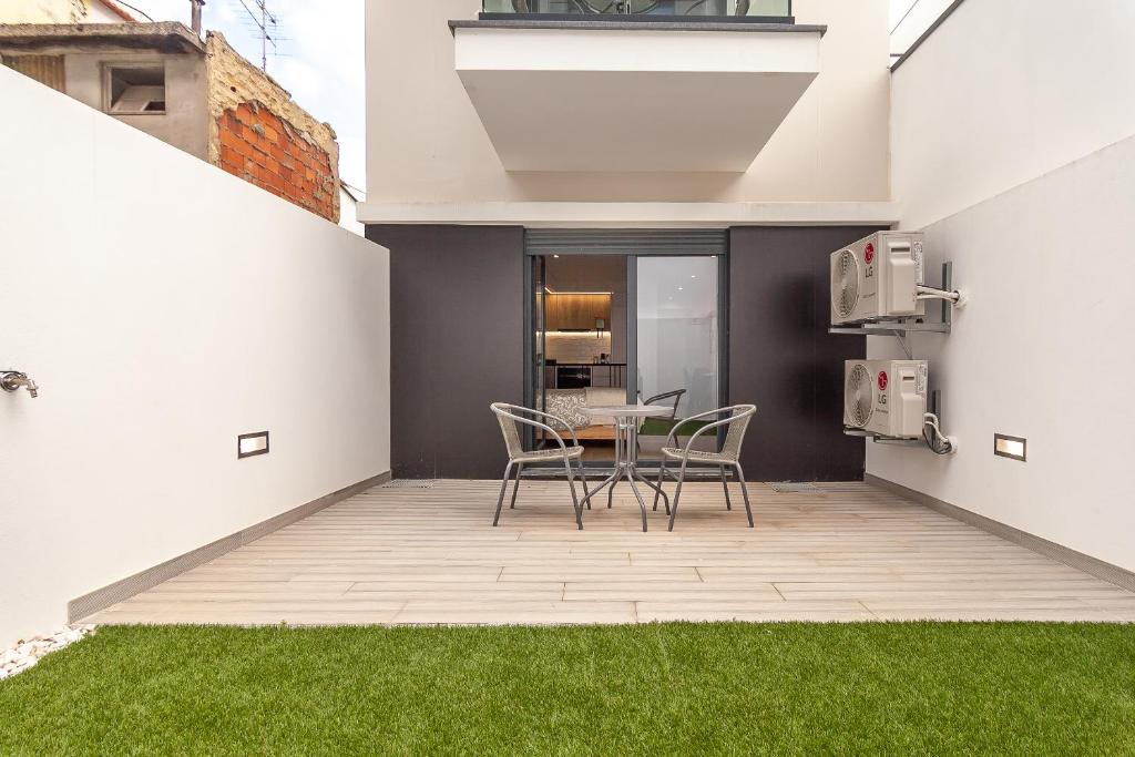 une terrasse avec des chaises et une table dans une maison dans l'établissement Gravito 53 Apartments by Home Sweet Home Aveiro, à Aveiro