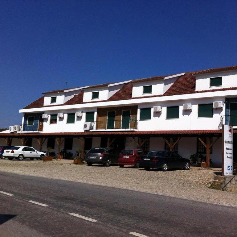 a large white building with cars parked in front of it at Capitolio in Macedo de Cavaleiros