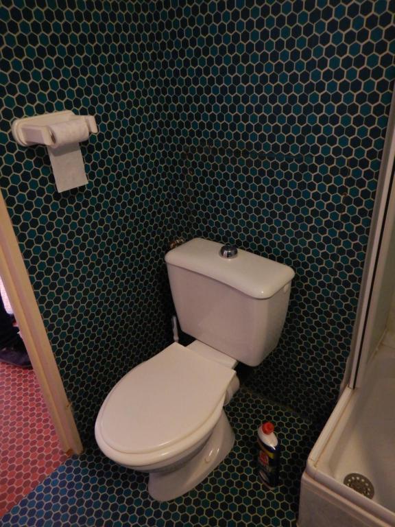 Łazienka z toaletą i zieloną ścianą wyłożoną kafelkami w obiekcie Appartement 4 personnes - Argelès-sur-Mer w Argelès-sur-Mer