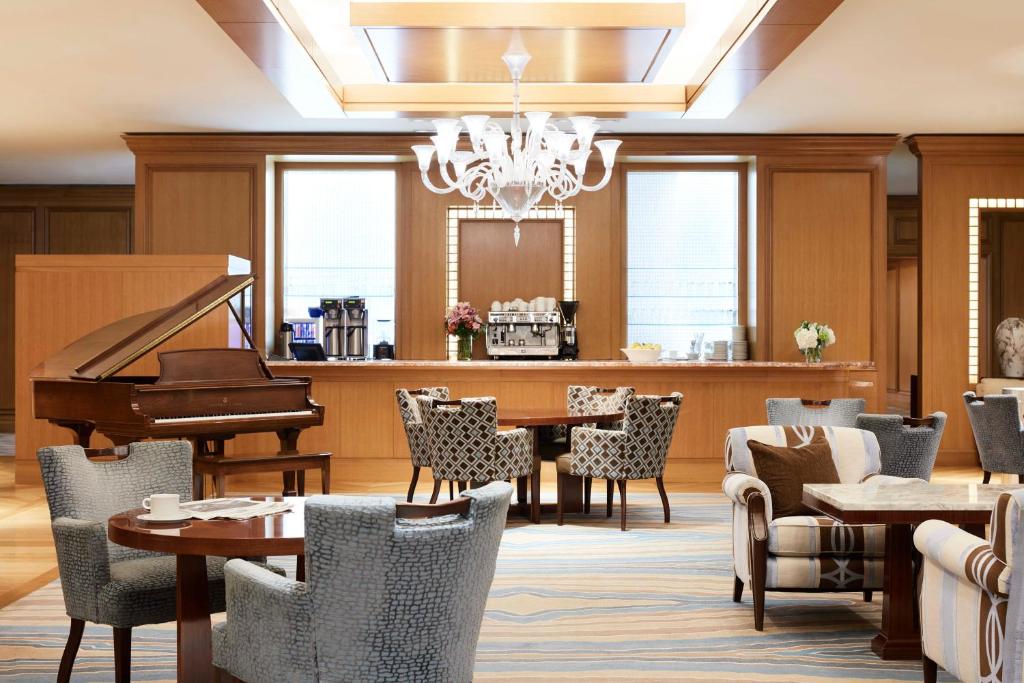 a restaurant with a piano and a table and chairs at Little America Hotel Salt Lake City in Salt Lake City