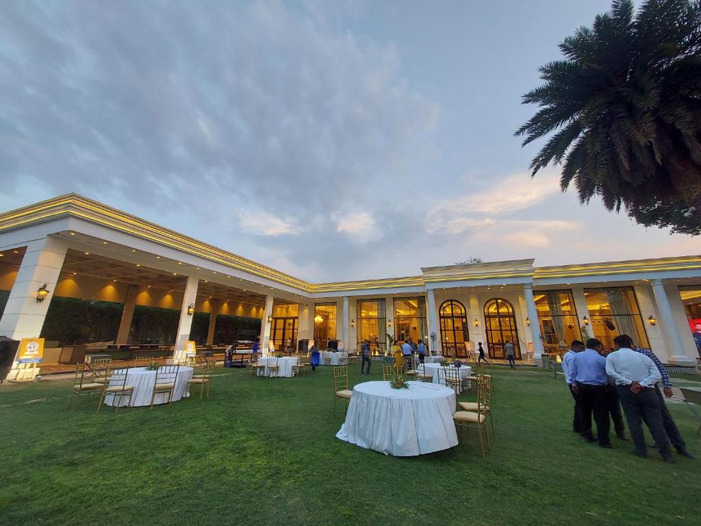a group of people standing around a table in front of a building at Kingston Resort in Kānpur