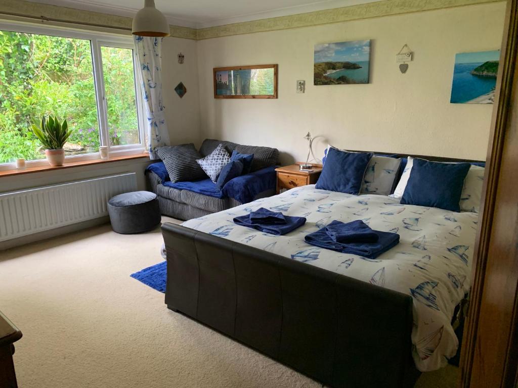 a bedroom with a bed and a couch in it at West Winds, Fore Street, Polruan by Fowey in Polruan