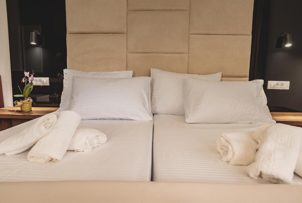 uma cama com lençóis brancos e almofadas em RIBAR APARTMENTS em Ohrid