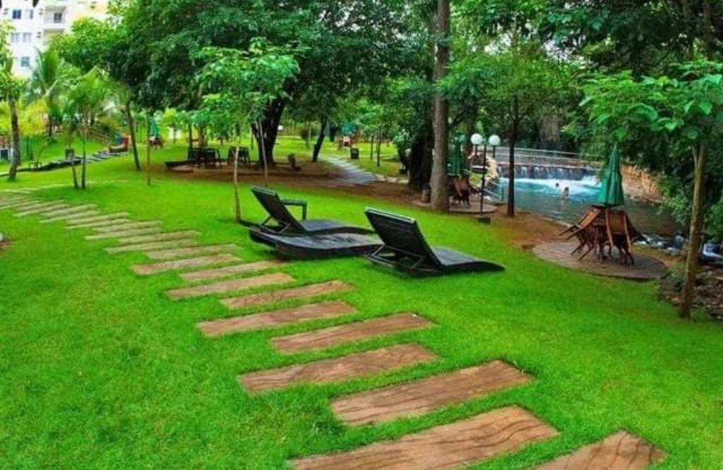 a park with two chairs and a rock pathway at Apartamento mobiliado para temporada-Rio Quente in Rio Quente