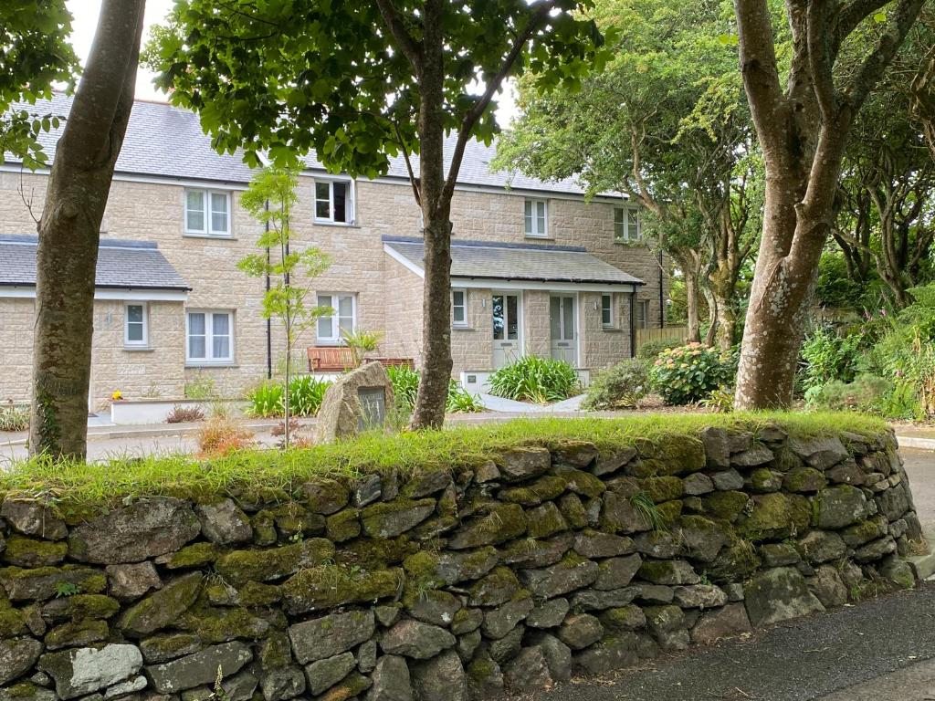 a stone wall in front of a house at Tinners Rest your comfortable holiday retreat in Lower Boscaswell
