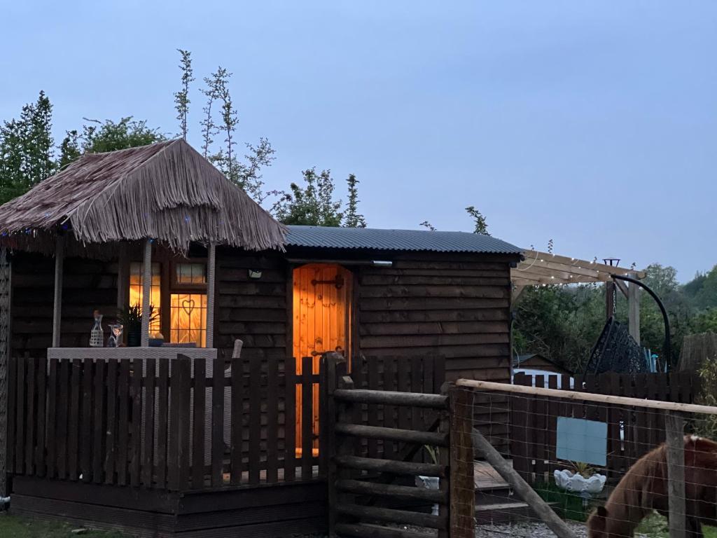 una piccola cabina in legno con una recinzione di fronte ad essa di Four seasons small holding a Hereford