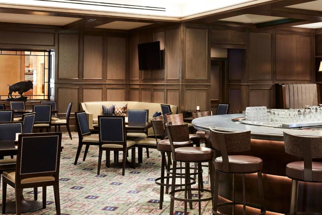 a large room with tables and chairs and a television at Little America Hotel Salt Lake City in Salt Lake City