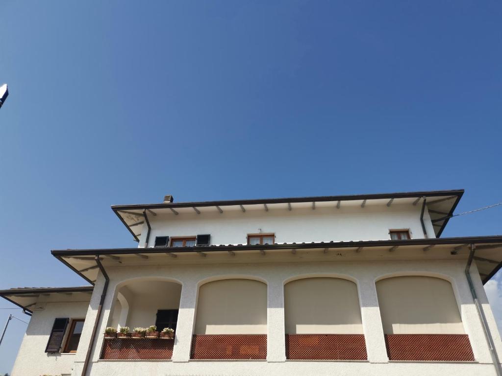 un edificio con ventanas y un cielo azul en el fondo en Villa Flora Affittacamere, en Luni
