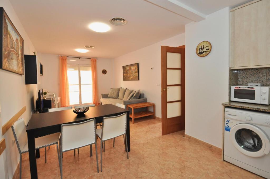 cocina y sala de estar con mesa y sillas en APARTAMENTO A PIE DE LA PLAYA en Lloret de Mar