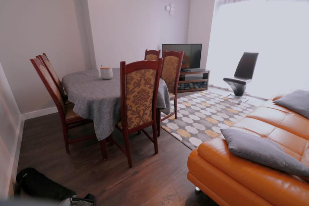 ein Wohnzimmer mit einem Tisch, Stühlen und einem Sofa in der Unterkunft A stylish four bedroom house in wollaton in Nottingham