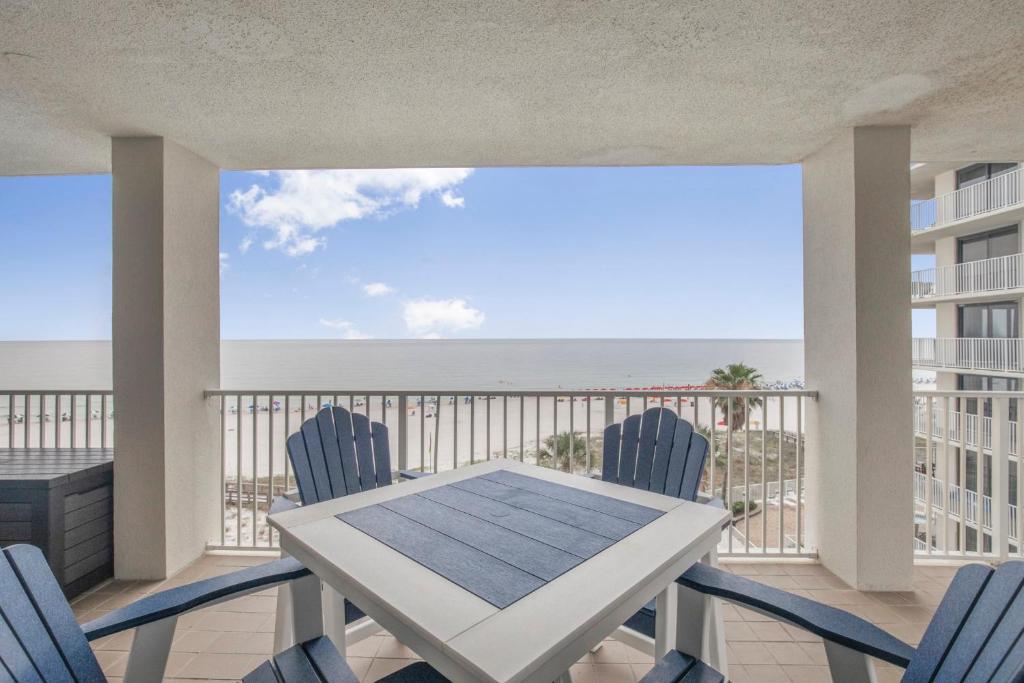 einen Balkon mit einem Tisch, Stühlen und Meerblick in der Unterkunft Pelican Pointe 506 by Vacation Homes Collection in Orange Beach